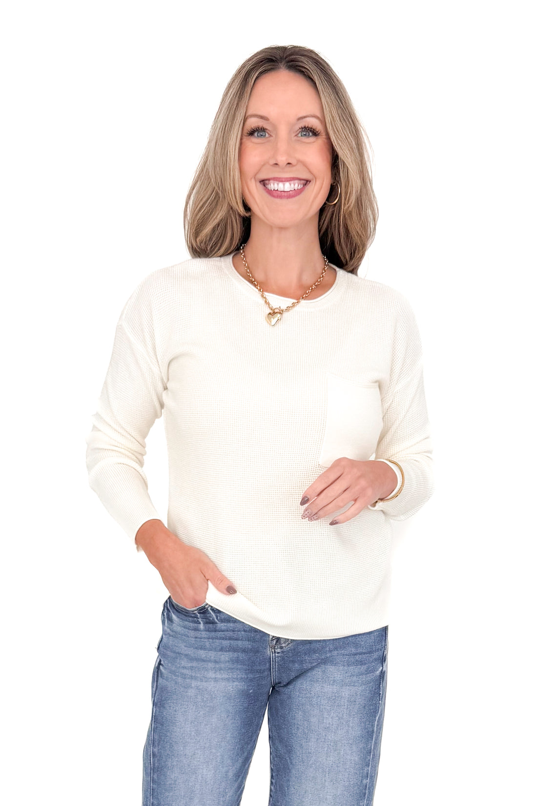 Front view of woman wearing Ivory Textured Pocket Detail Sweater with jeans against white studio background.