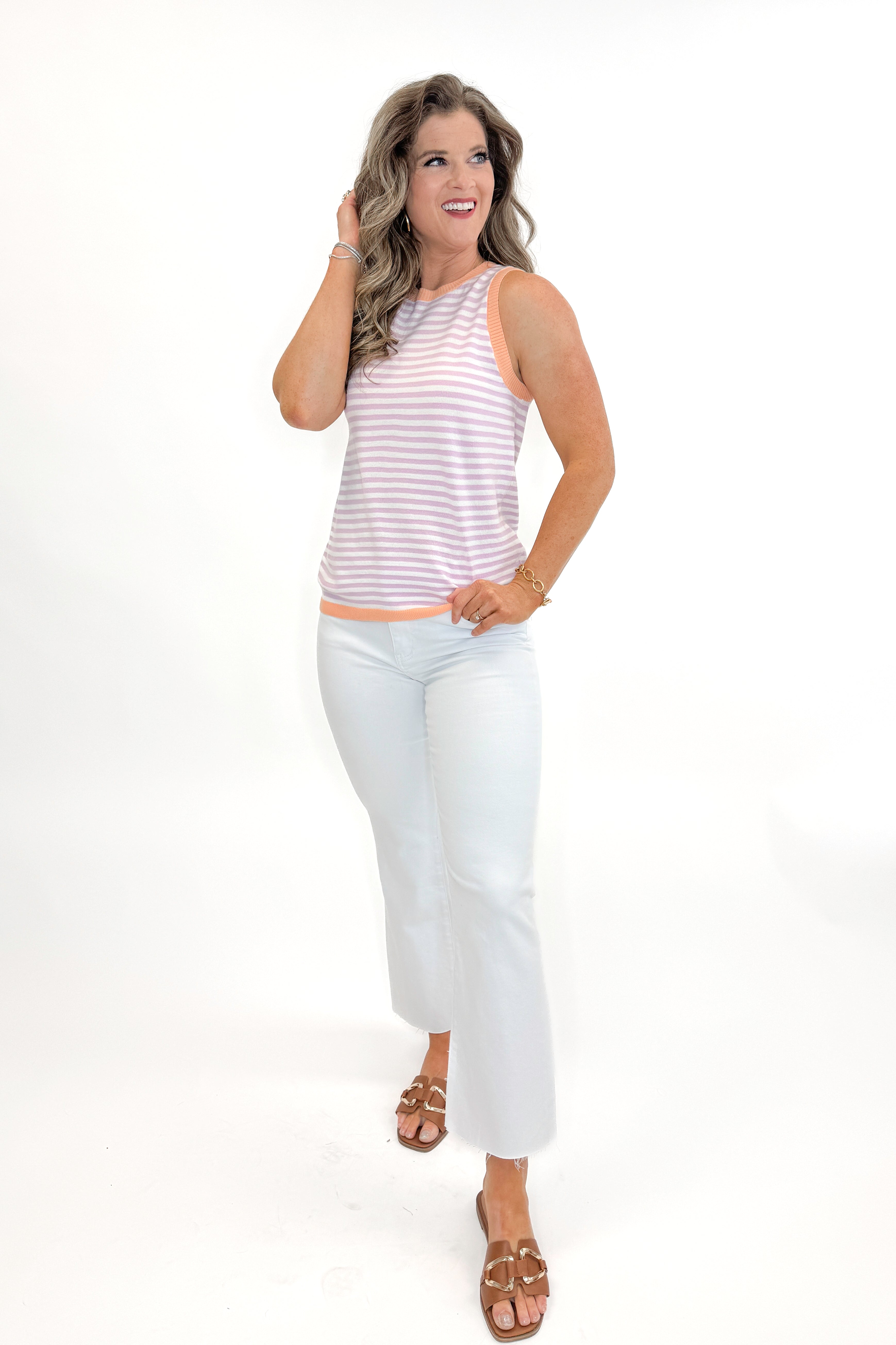 Front view of woman wearing Lavender &amp; Orange Striped Sweater Tank with jeans against white studio background.