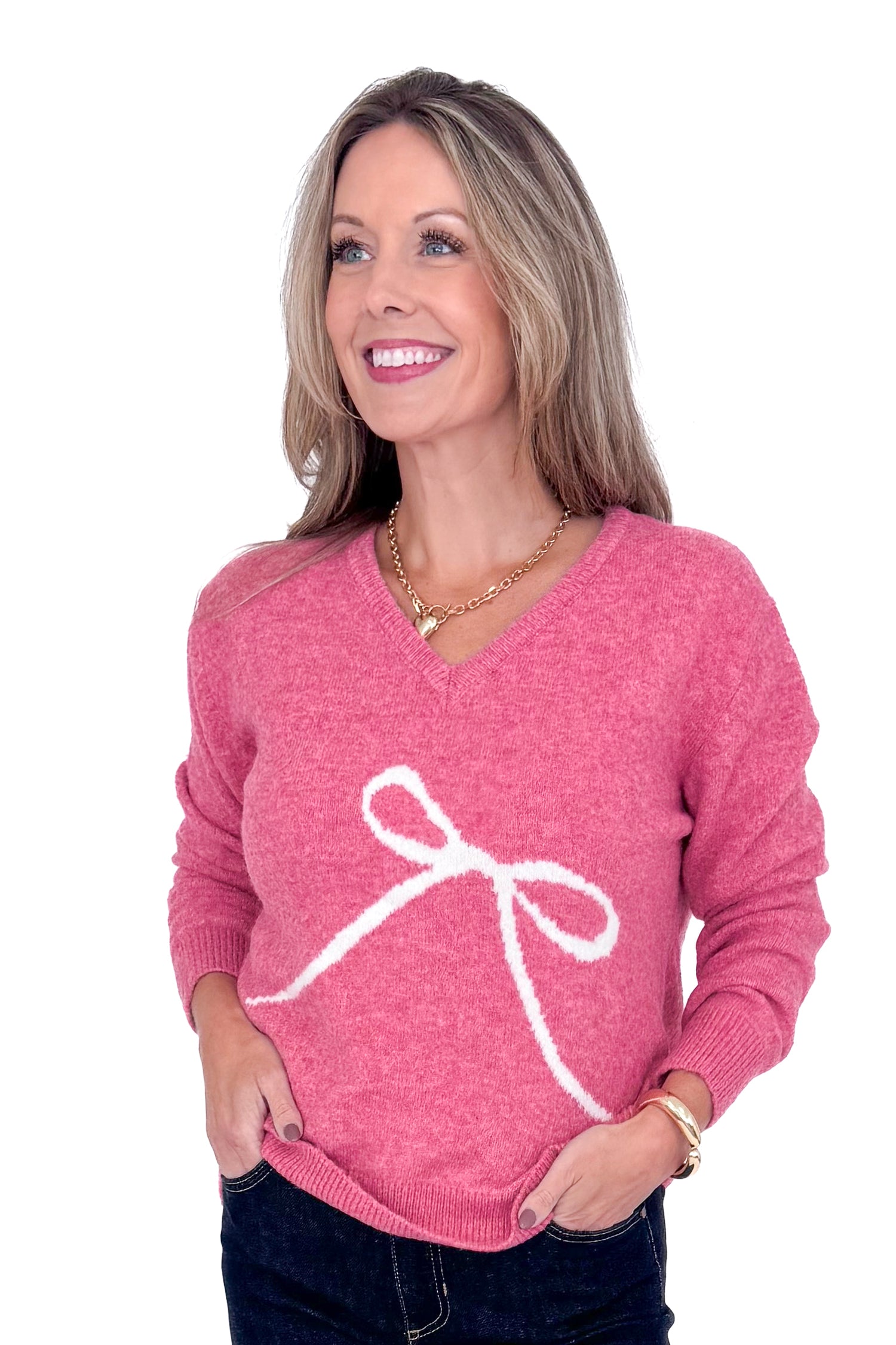 Front detailed view of woman wearing Pink Bow Printed Sweater and blue jeans. 