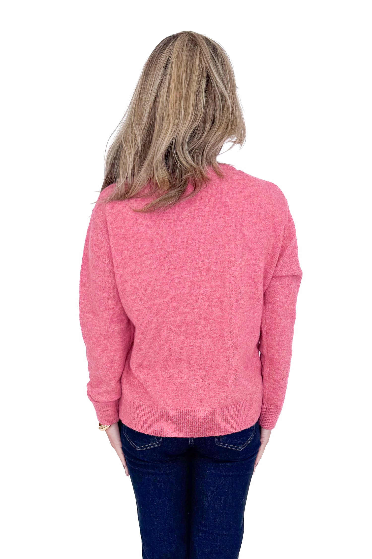 Back view of woman wearing Pink Bow Printed Sweater and blue jeans. 