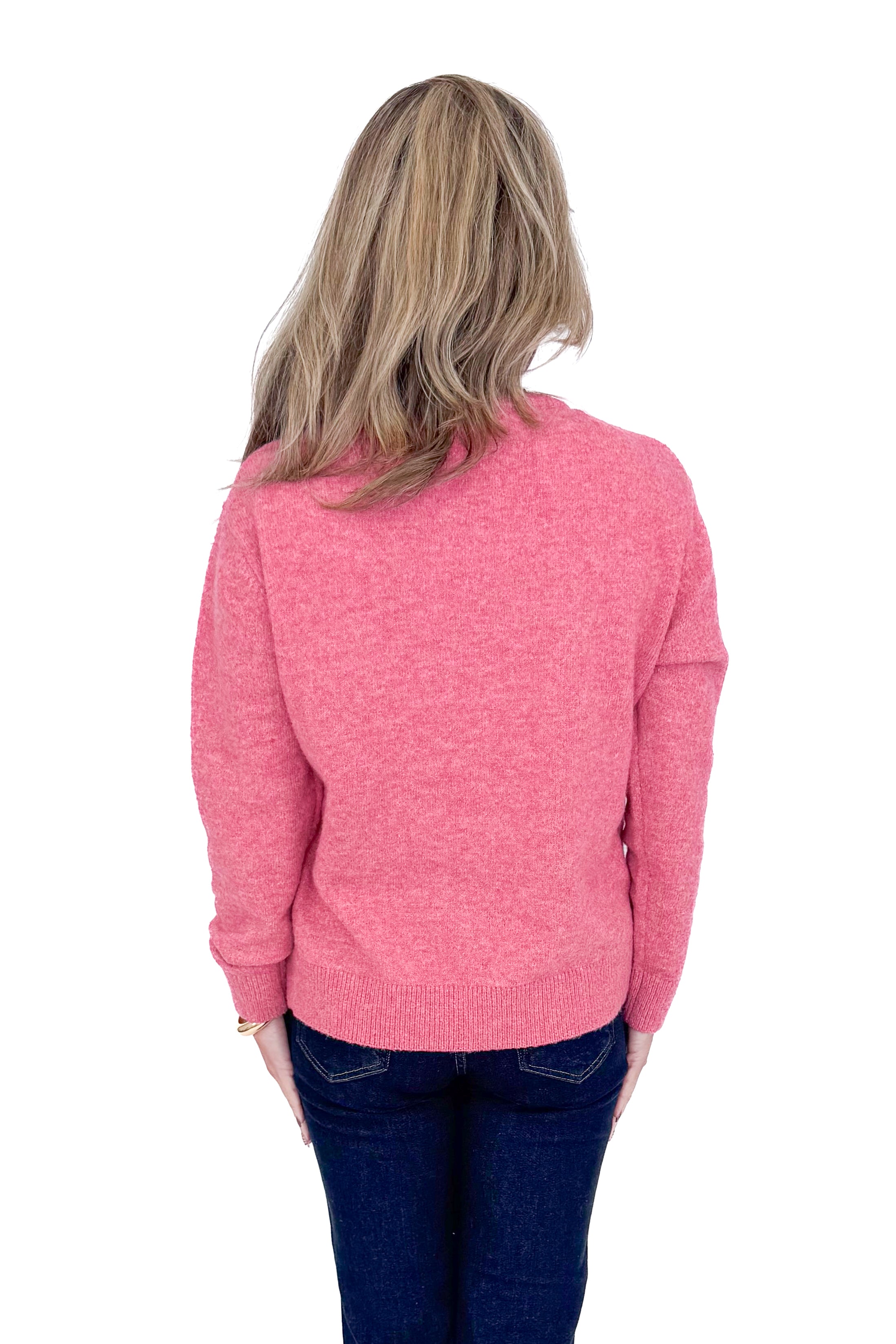 Back view of woman wearing Pink Bow Printed Sweater and blue jeans. 