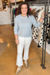 Front view of woman wearing Light Blue Ribbed Sweater with white jeans at a boutique.
