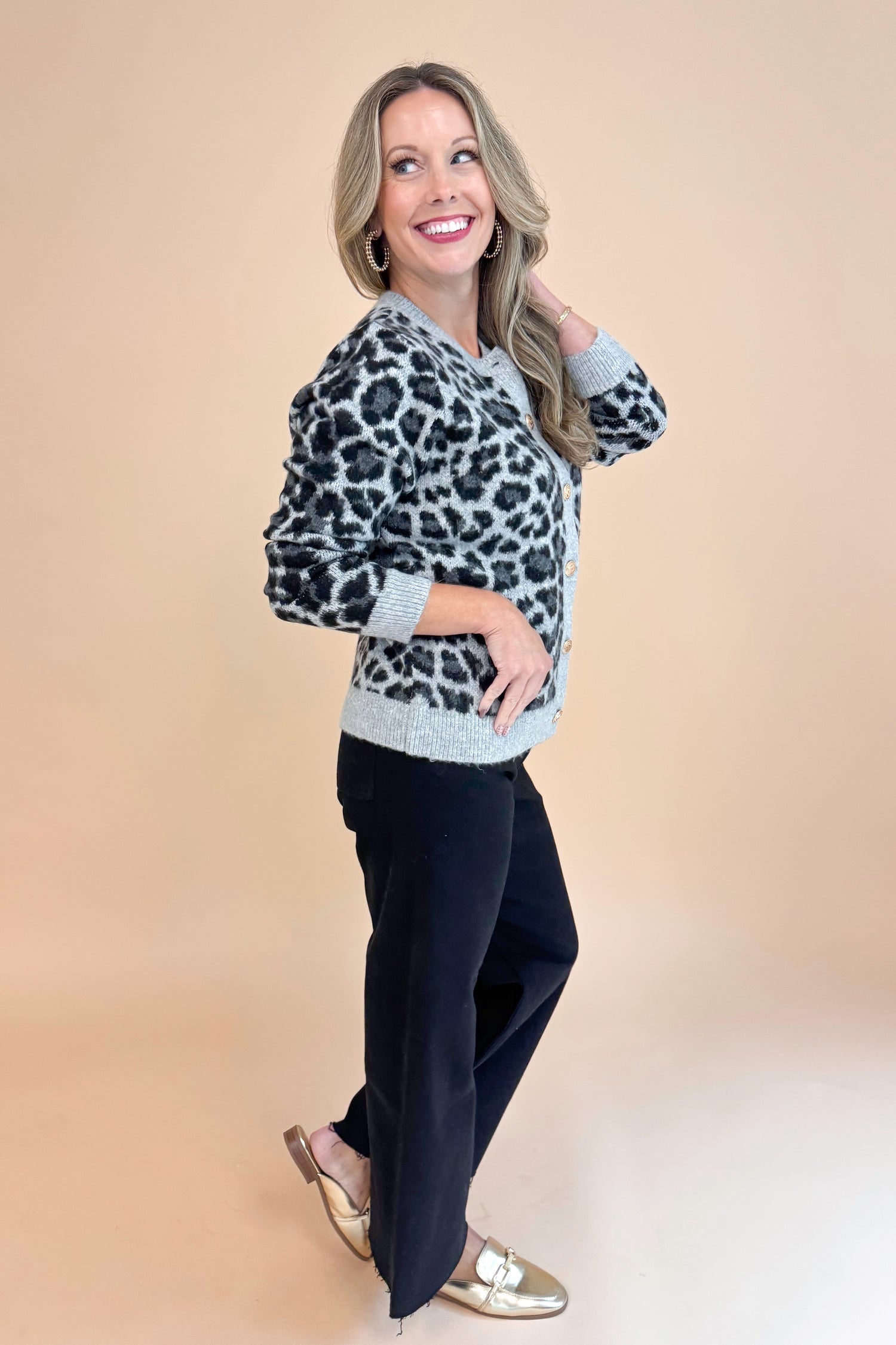 Side view of woman wearing Grey Leopard Button Up Cardigan and black jeans.