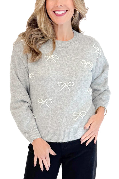 Detailed front view of woman wearing Grey Pearl Bow Detail Sweater. 