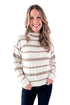 Front view of woman wearing Taupe and Cream Striped Mock Neck Sweater with jeans against white studio background.