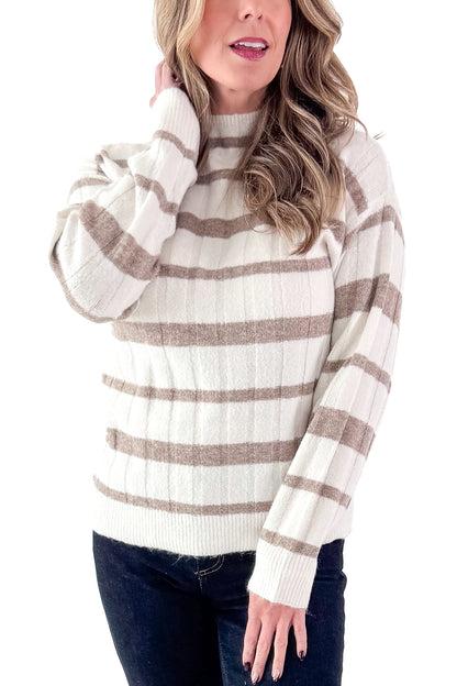 Front detailed view of woman wearing Taupe and Cream Striped Mock Neck Sweater with jeans against white studio background.