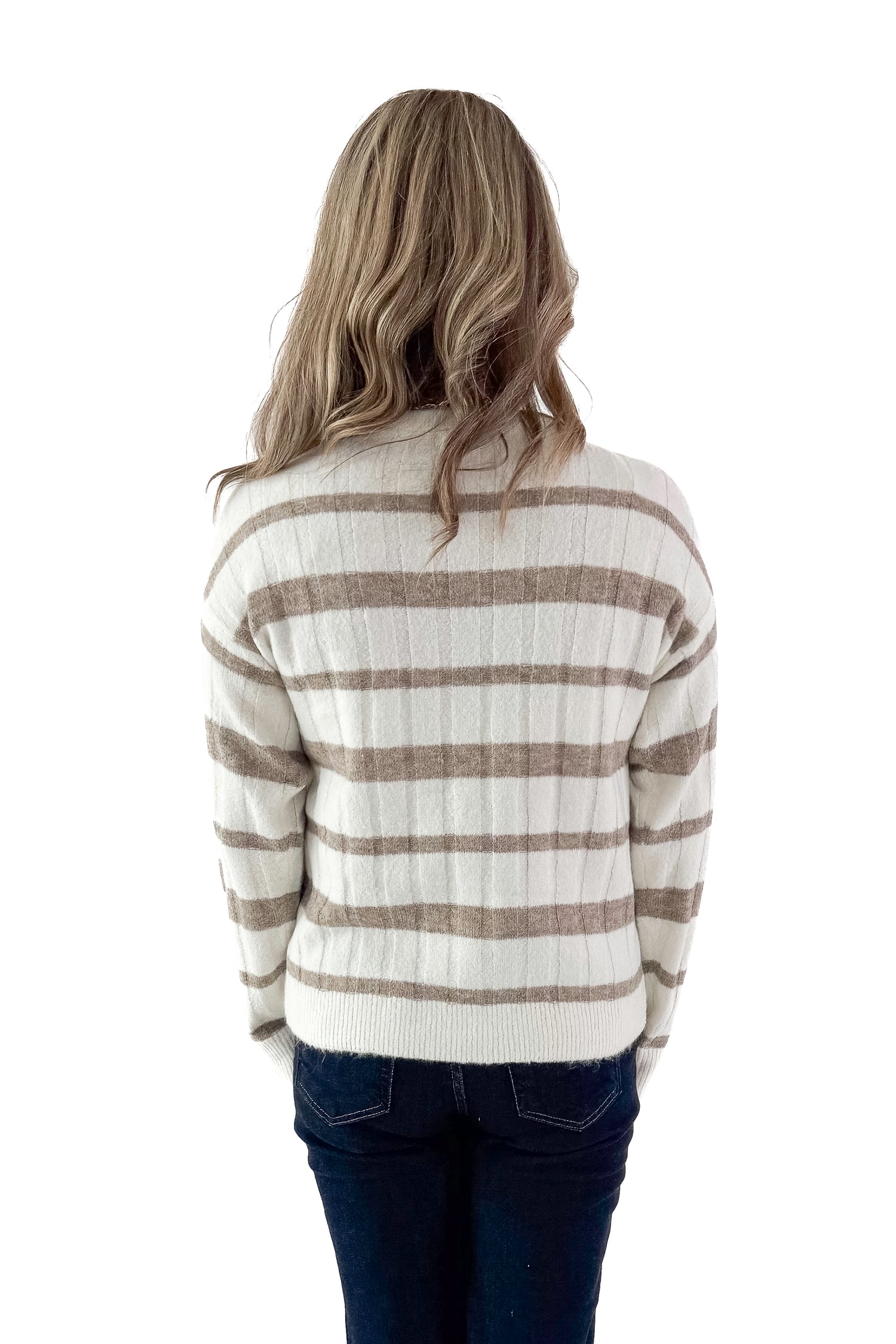 Back view of woman wearing Taupe and Cream Striped Mock Neck Sweater with jeans against white studio background.