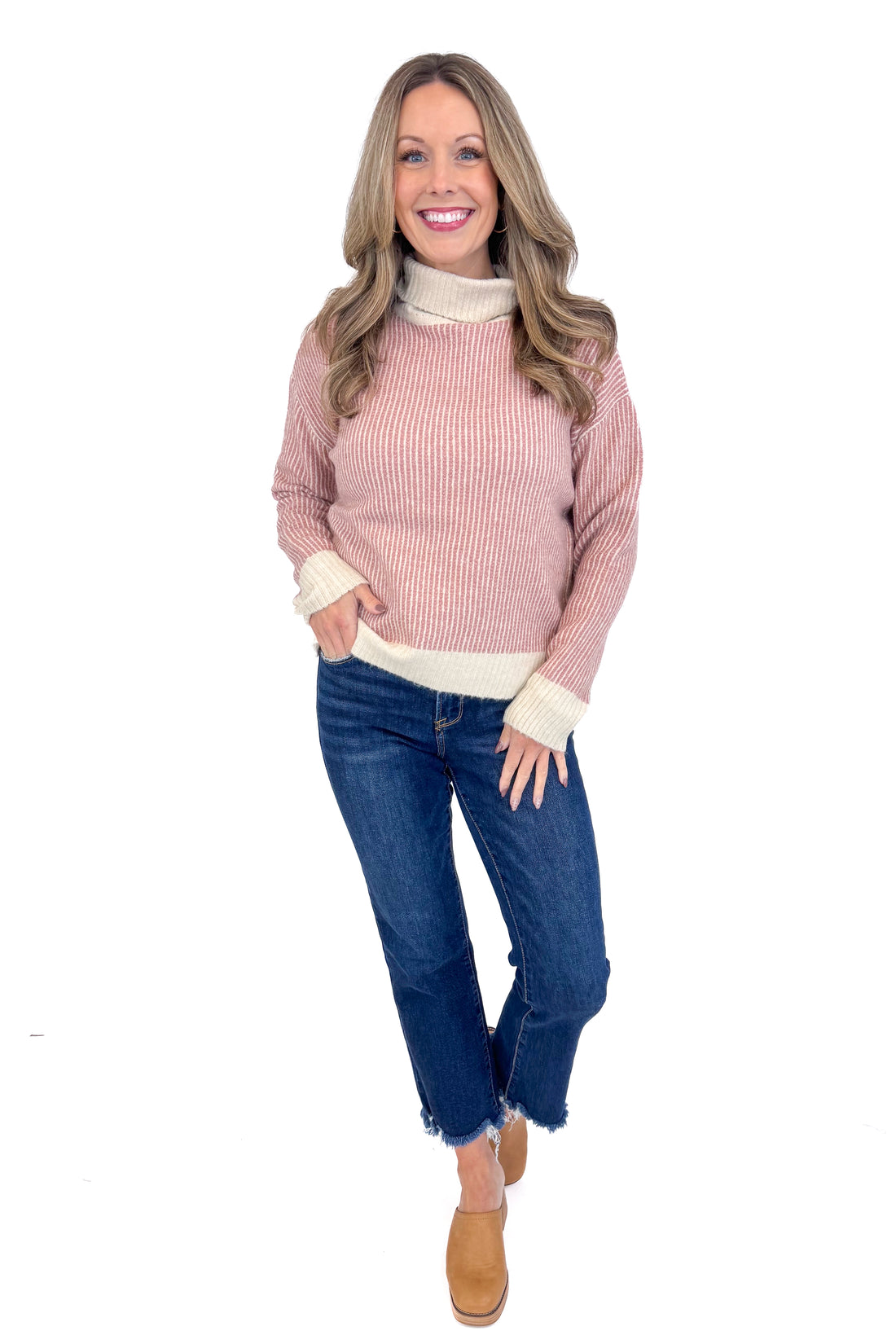 Front picture of woman wearing Mauve Striped Turtleneck Sweater and blue jeans against a white background.