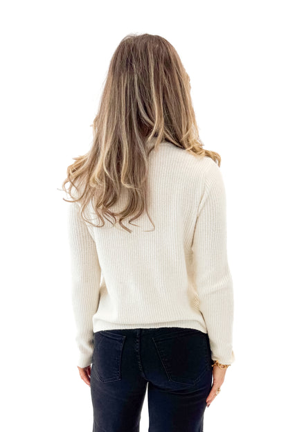 Back view of woman wearing Ivory Bow Pocket Detail Cardigan with jeans against white studio background.