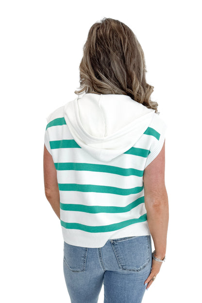 Back view of woman wearing Green Striped Sleeveless Sweater with jeans against white studio background.
