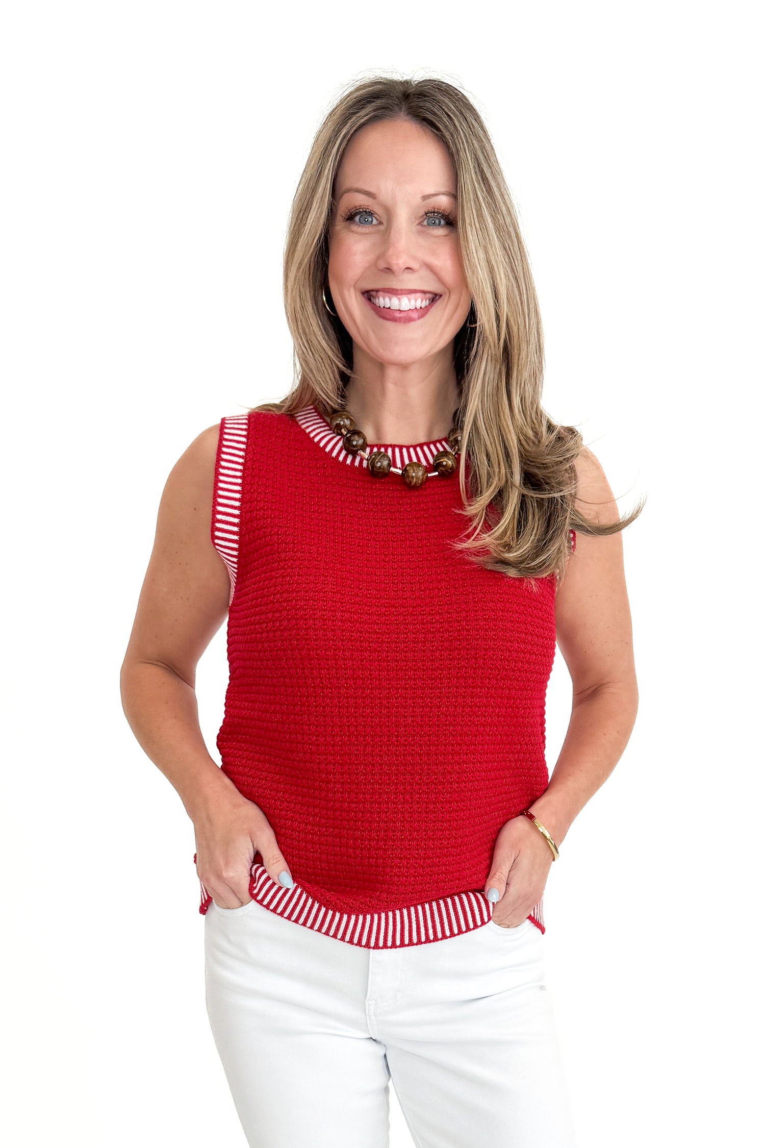 Front view of woman wearing Red &amp; White Textured Sweater Tank with jeans against white studio background.