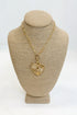 Gold necklace with a heart-shaped pendant on a beige mannequin bust against a white background