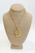 Gold necklace with a pendant on a beige mannequin bust against a white background