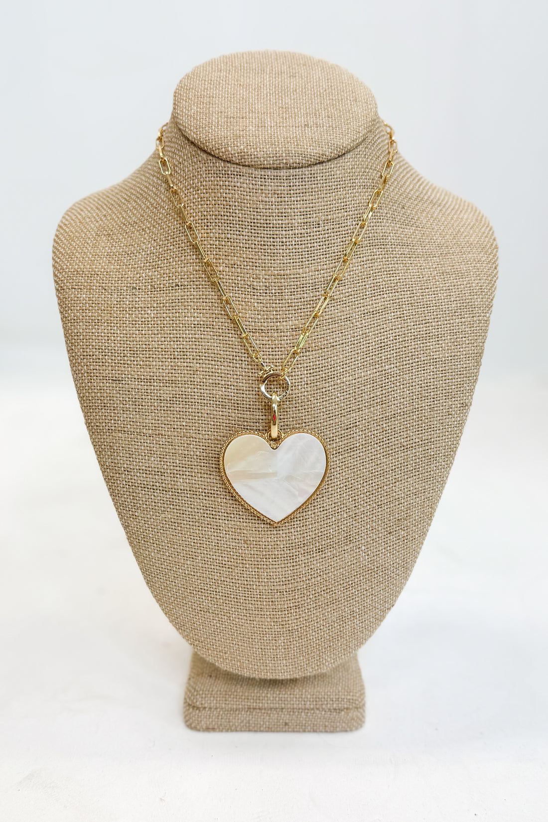 Necklace with a heart-shaped pendant on a mannequin bust against a white background