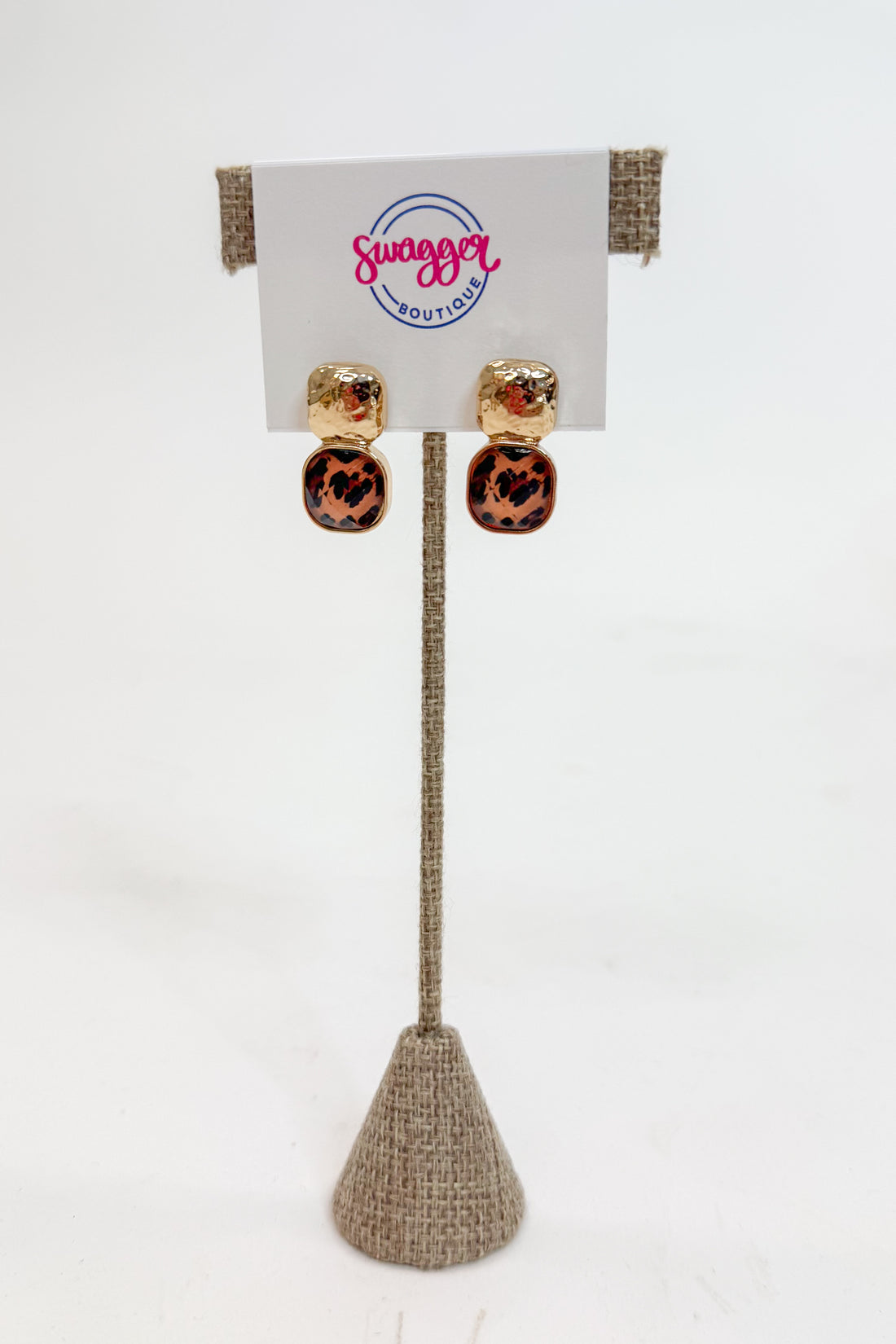 Pair of earrings on a stand with a Swagger Boutique card in the background
