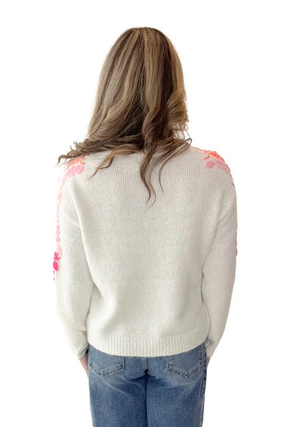 Back view of woman wearing Ivory With Floral Embroidery Sweater with jeans against white studio background.