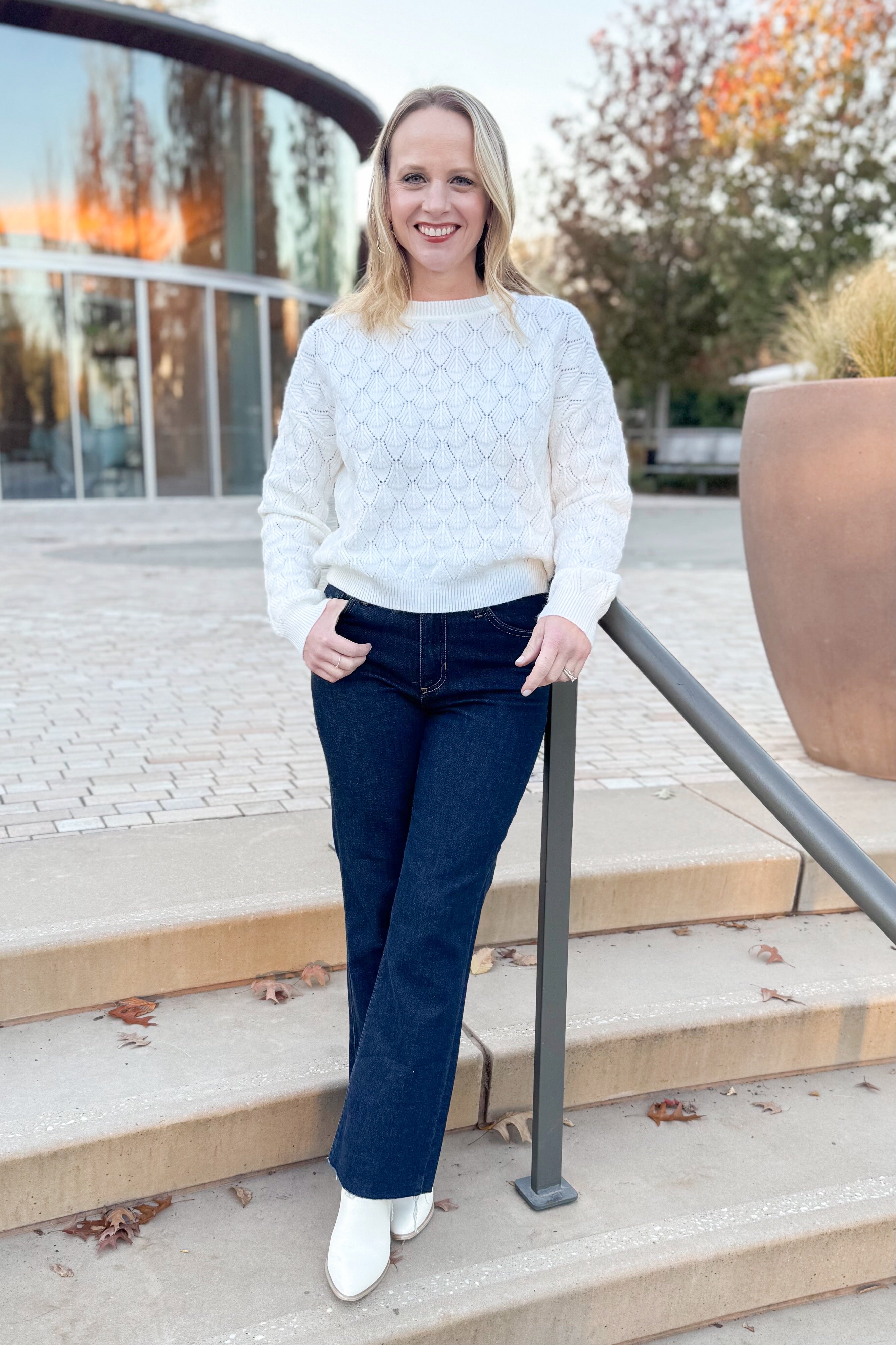 Front view of woman wearing Ivory Textured Knit Sweater and jeans outside.