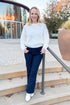 Front view of woman wearing Ivory Textured Knit Sweater and jeans outside.