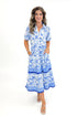 Front view of woman wearing Blue Floral Eloise Dress by Mary Square with sandals against white studio background.