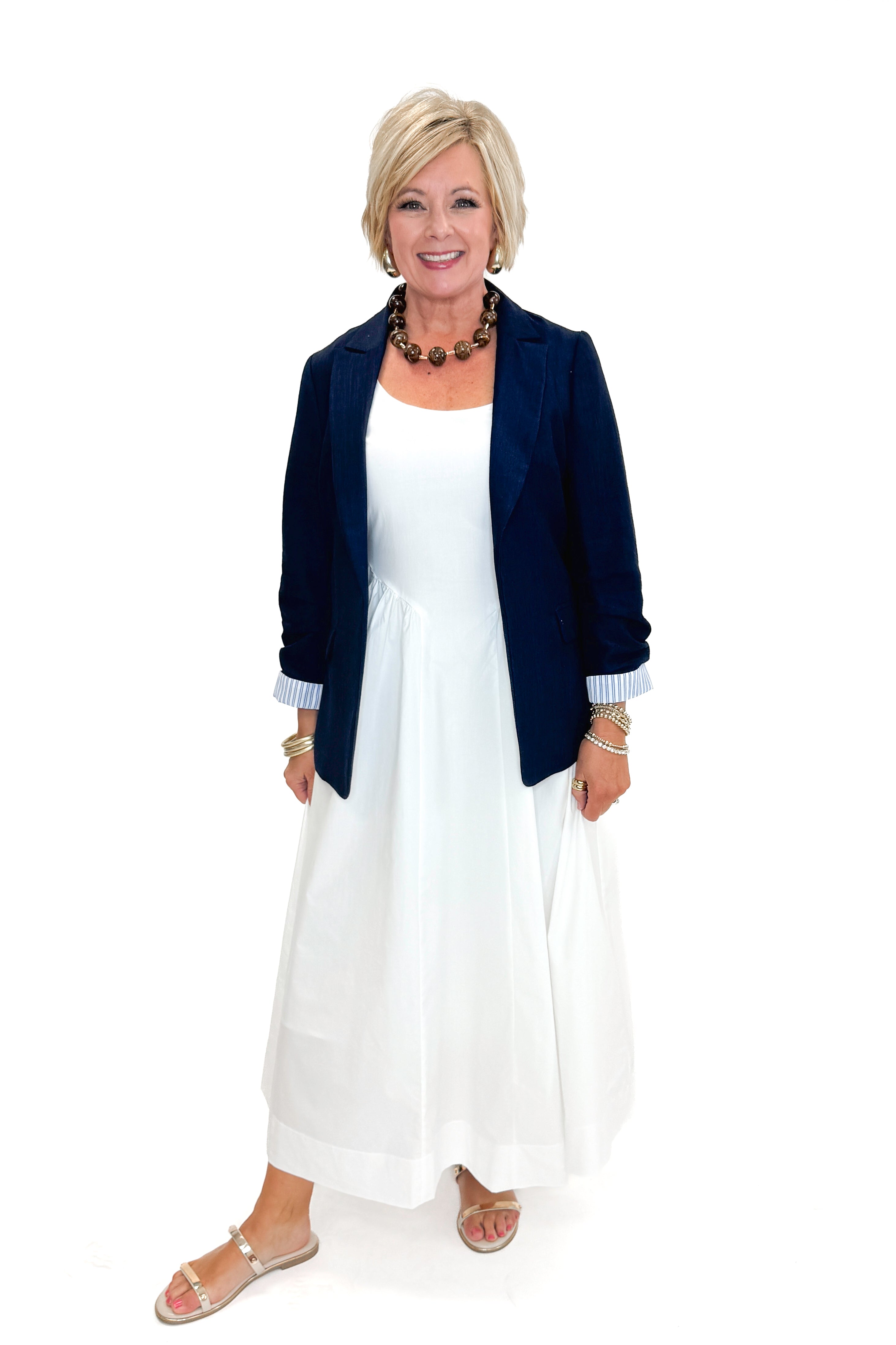 Front view of woman wearing Off White A-Line Midi Dress by PINCH with navy blazer against white studio background.
