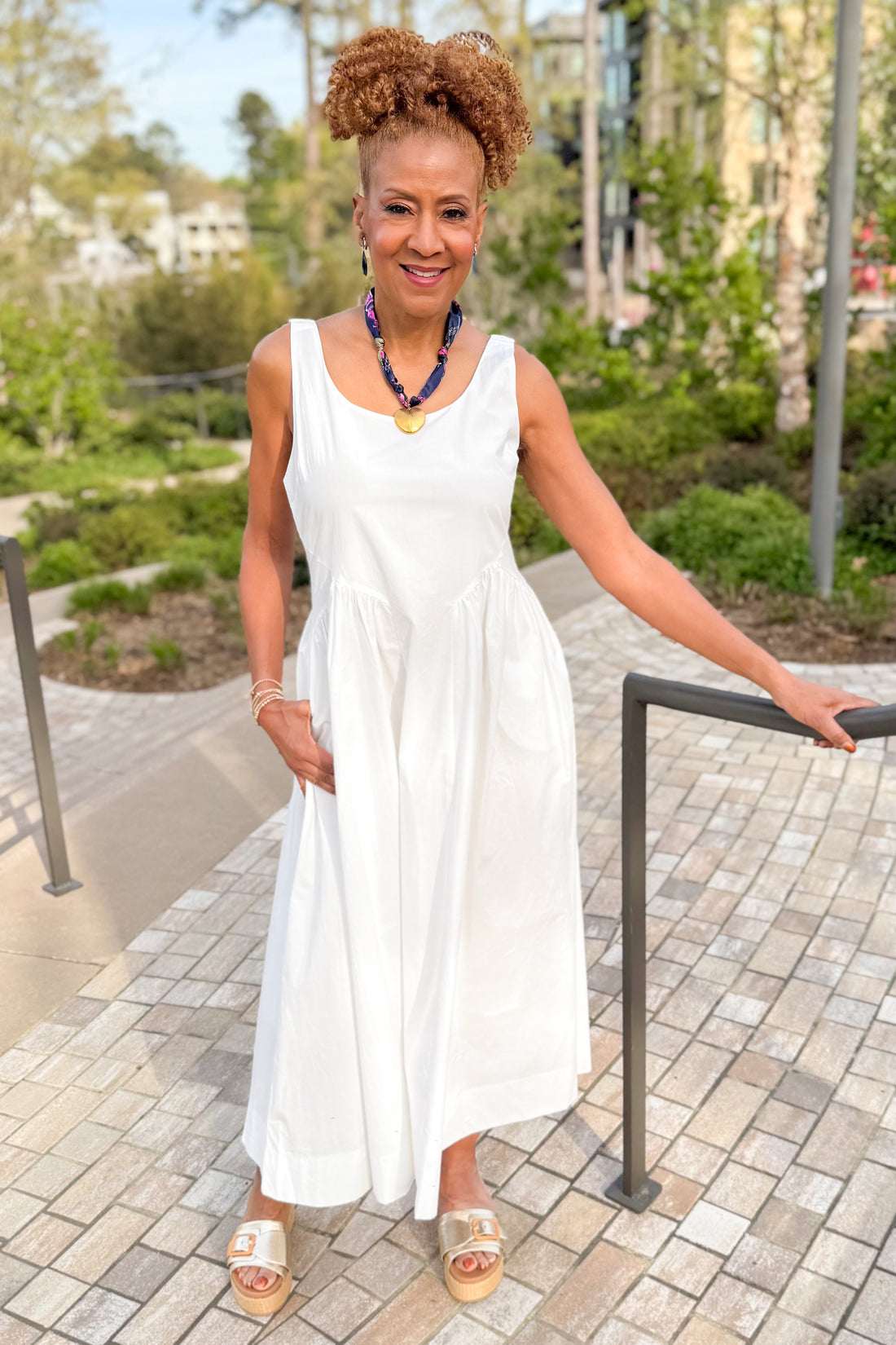 Front view of woman wearing Off White A-Line Midi Dress by PINCH with sandals outside at a park.