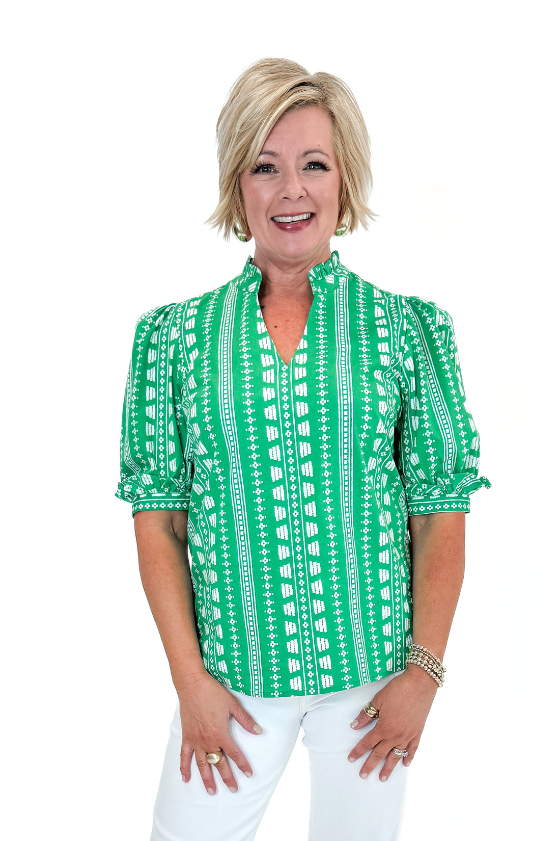 Front view of woman wearing Green Printed Colette Top by Mary Square with jeans against white studio background.