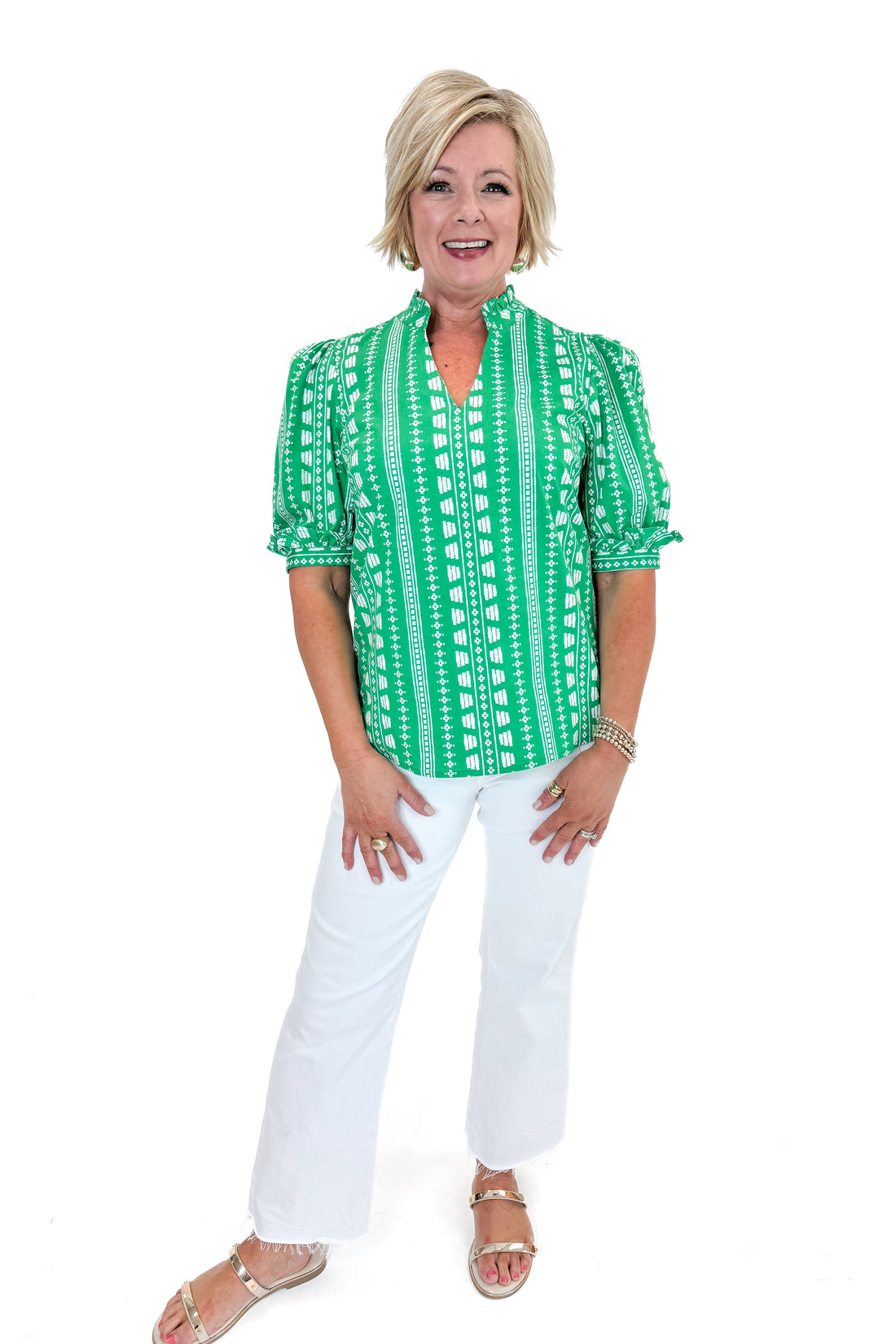 Front view of woman wearing Green Printed Colette Top by Mary Square with jeans against white studio background.