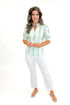 Front view of woman wearing Blue & Green Vine Print Colette Top by Mary Square with jeans against white studio background.