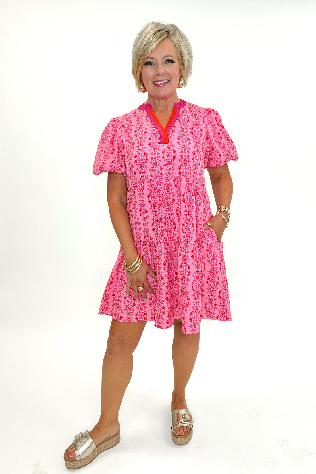 Front view of woman wearing Pink Vine Print Kinsley Midi Dress by Mary Square with sandals against white studio background.