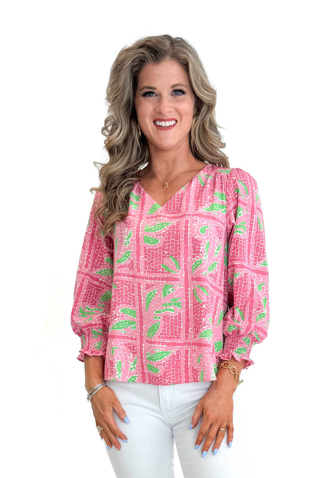 Front view of woman wearing Pink Trellis Tiles Ashlyn Top by Mary Square with jeans against white studio background.