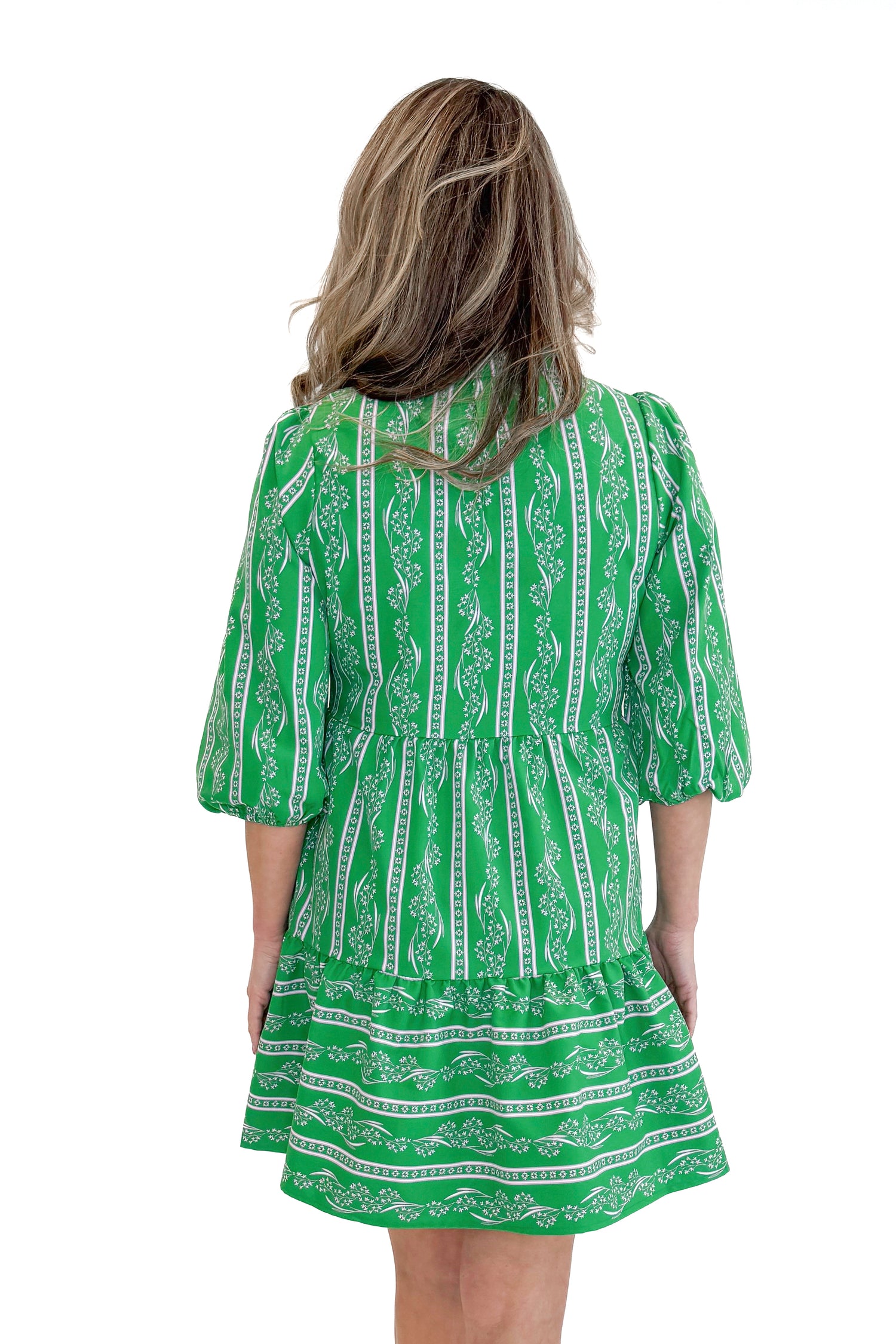 Model wearing Green Garden Lae Riley Mini Dress by Mary Square against white studio background back view.