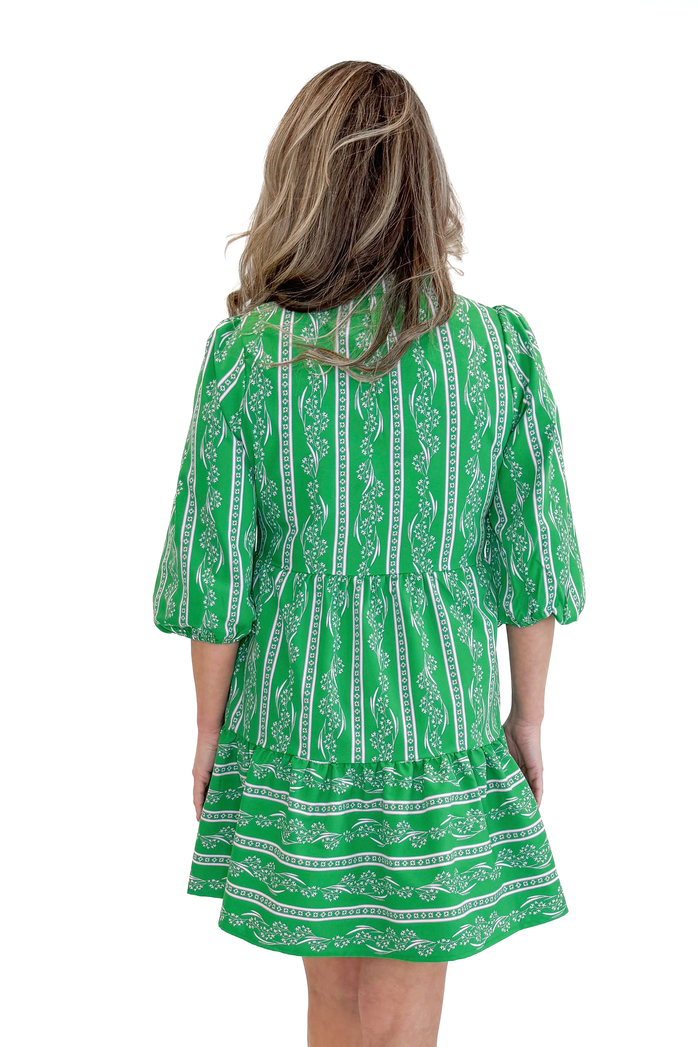 Model wearing Green Garden Lae Riley Mini Dress by Mary Square against white studio background back view.