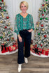 Woman standing in front of Christmas trees with decorated presents.