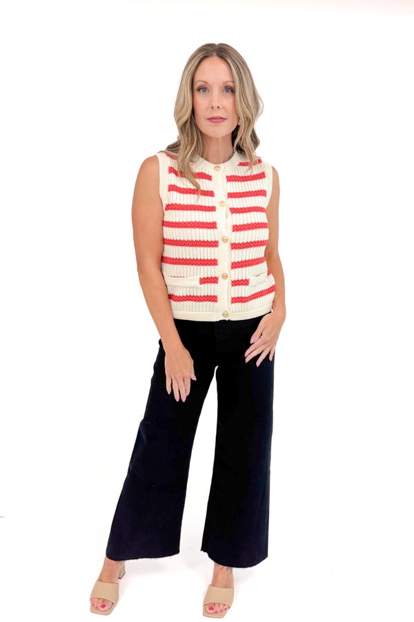 Woman wearing a red and white striped vest with black pants on a white background