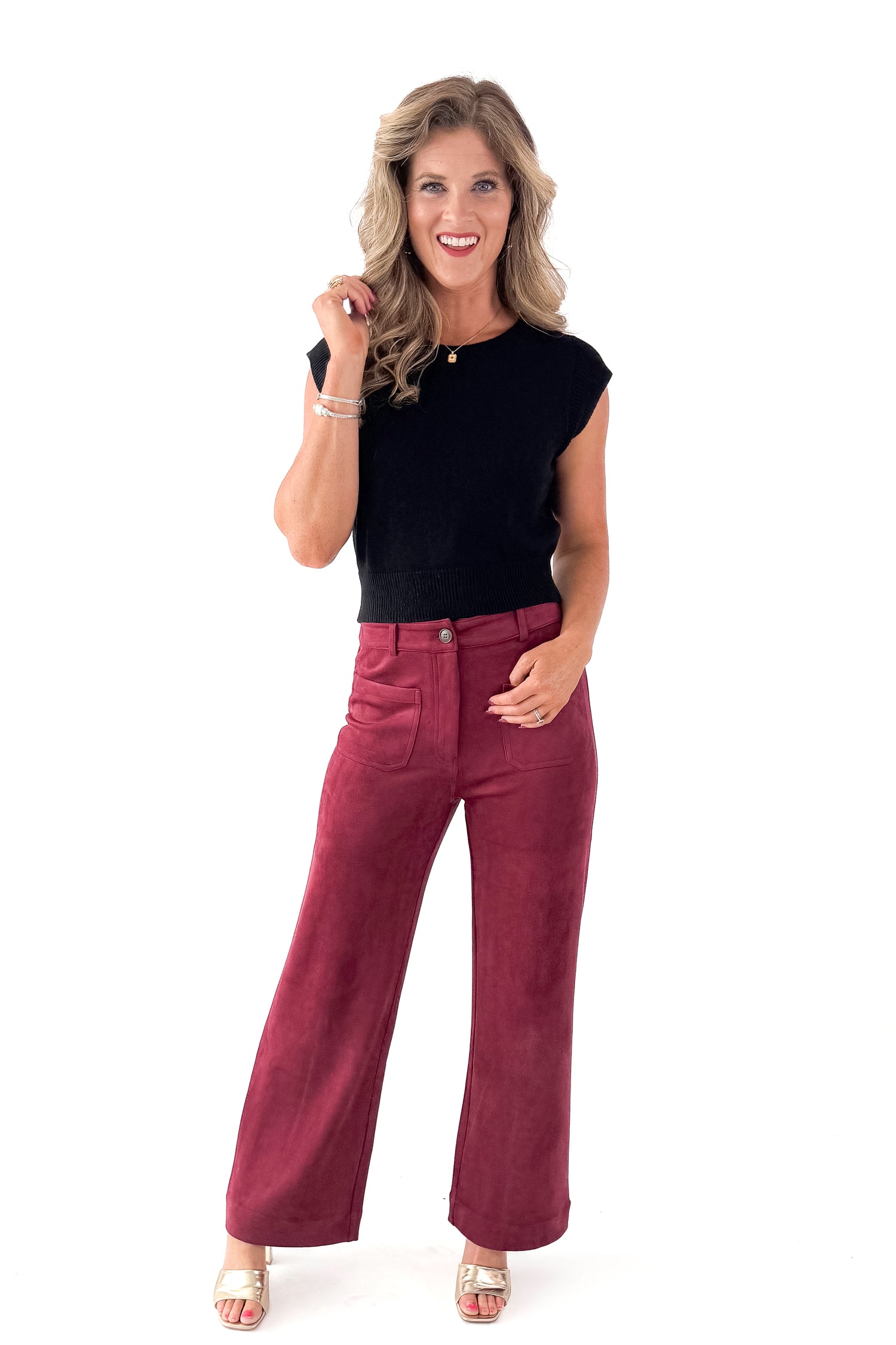 Front view of woman wearing sweater with Burgundy Suede Wide Leg Pants against white studio background.