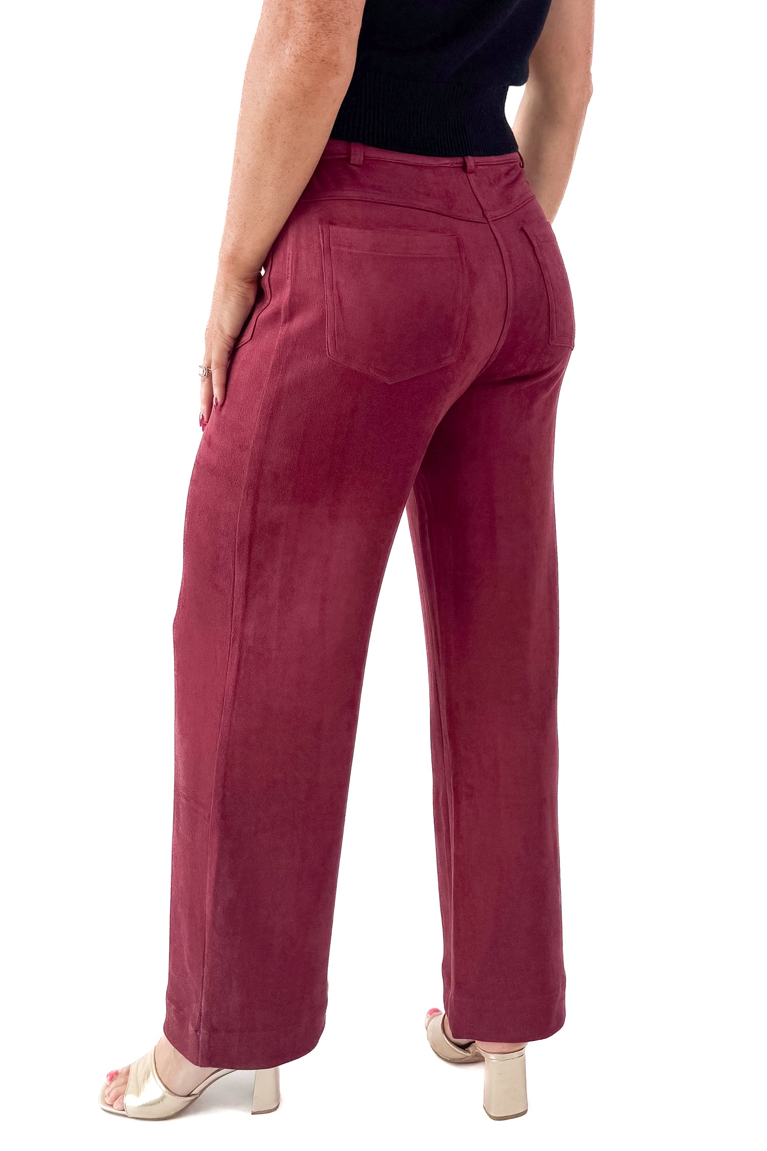 Side view of woman wearing sweater with Burgundy Suede Wide Leg Pants against white studio background.