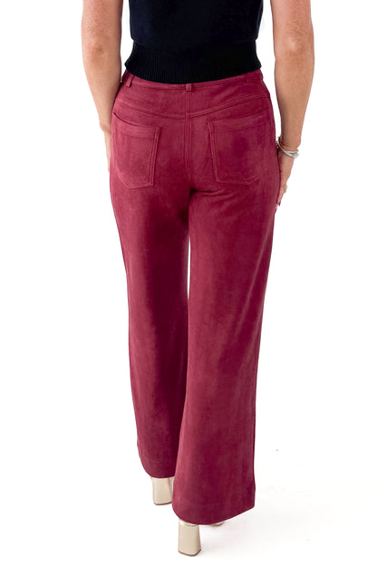 Back view of woman wearing sweater with Burgundy Suede Wide Leg Pants against white studio background.
