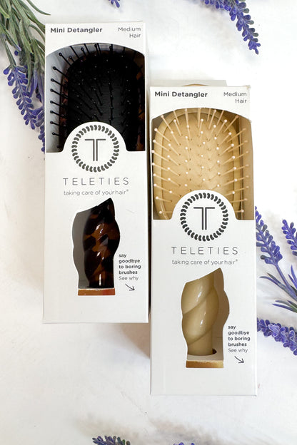 Two Teleties mini detanglers in packaging with lavender flowers in the background