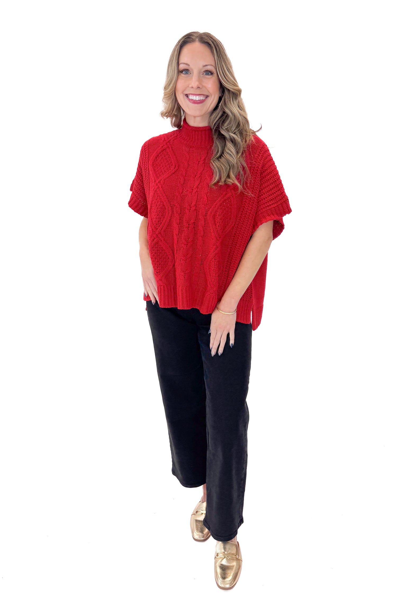 Front view of woman wearing Red Claude Cable Knit Sweater by MudPie with jeans against white studio background.