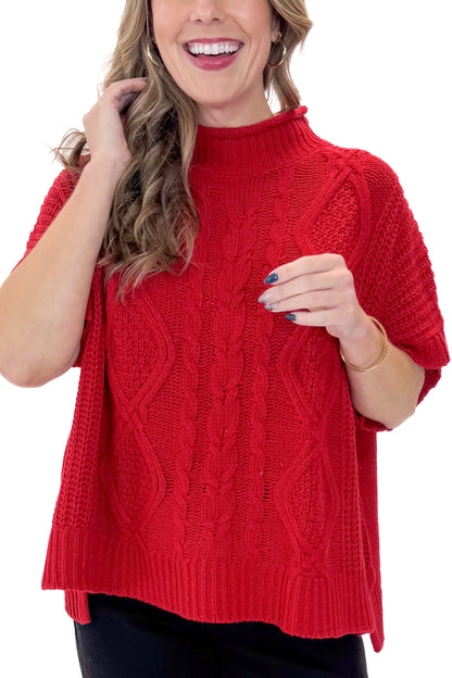 Front detail view of woman wearing Red Claude Cable Knit Sweater by MudPie with jeans against white studio background.