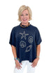 Front view of woman wearing Navy Hurley Beach Sweater by MudPie with jeans against white studio background.