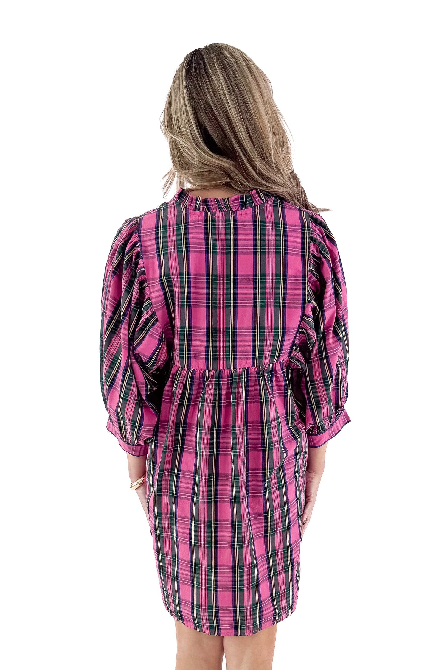 Back view of woman wearing Shipley pink plaid dress against white studio background.
