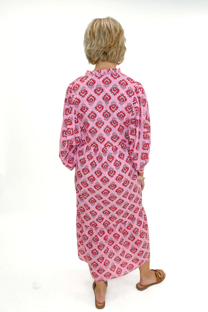 Back view of woman wearing Pink Waylon Midi Dress by MudPie against white studio background.