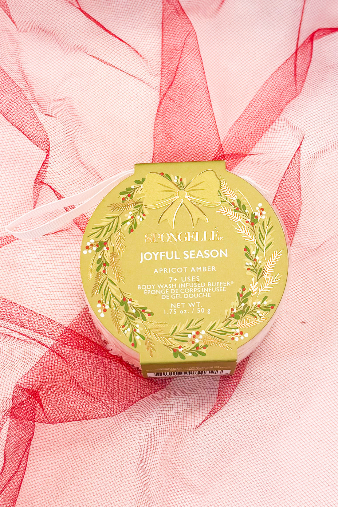 Green spongelle with decorative design on a pink fabric background