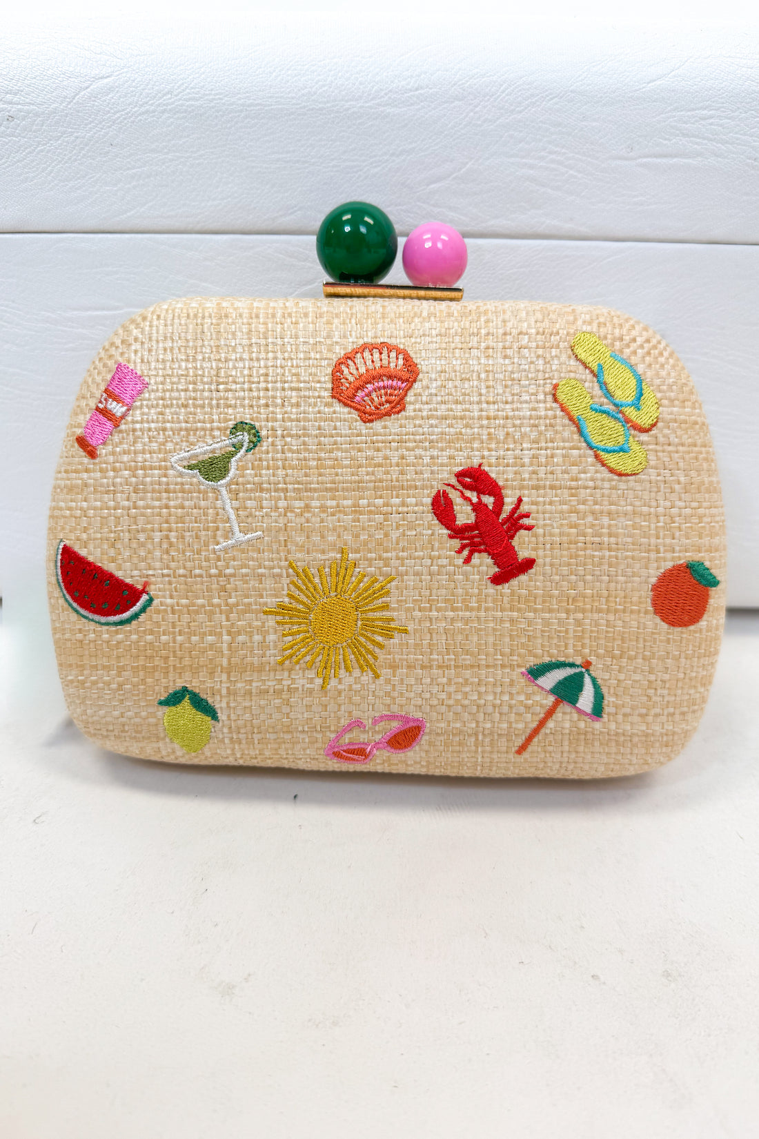 Woven clutch bag with colorful summer-themed decorations on a white background