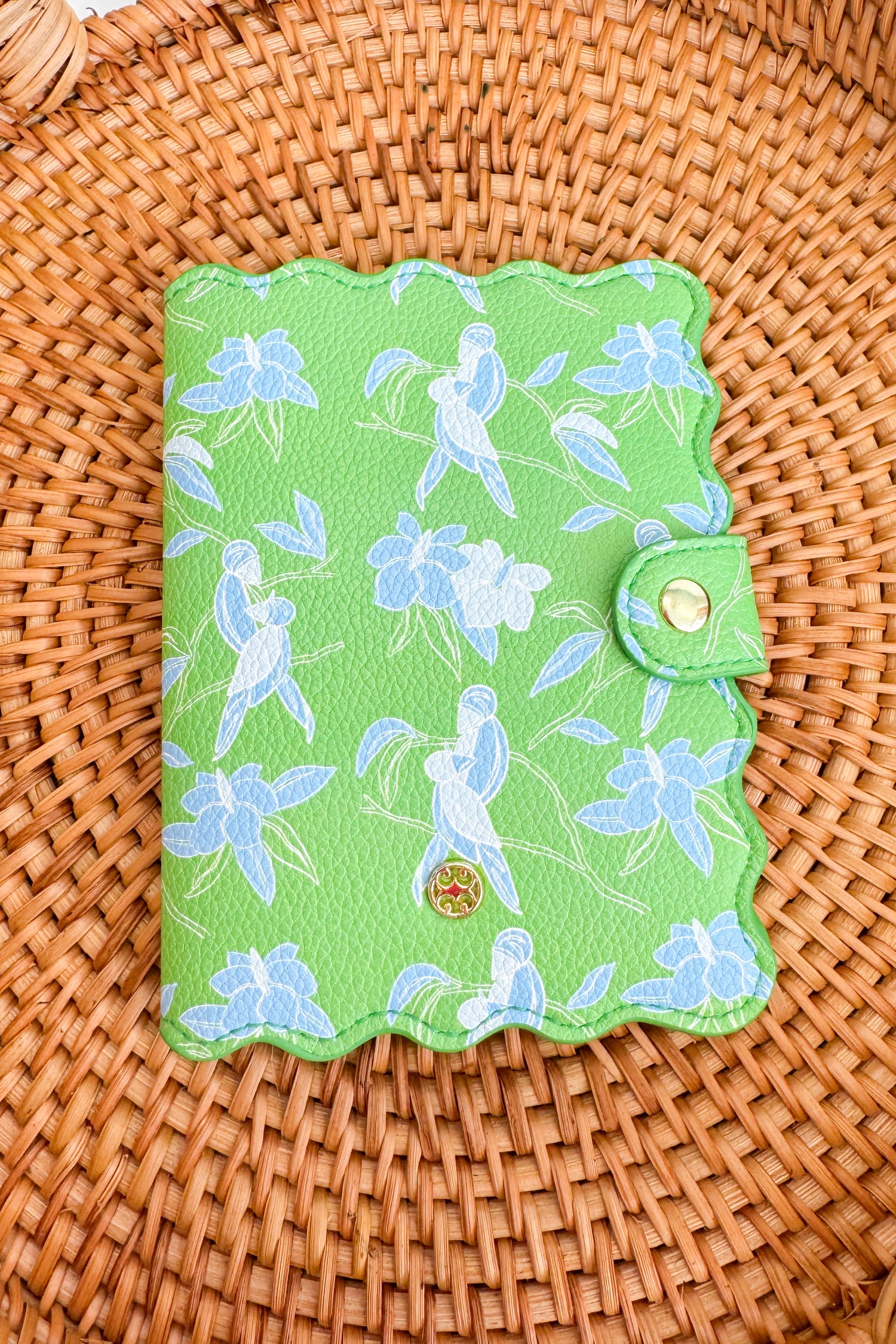 Green fabric passport cover on a woven surface