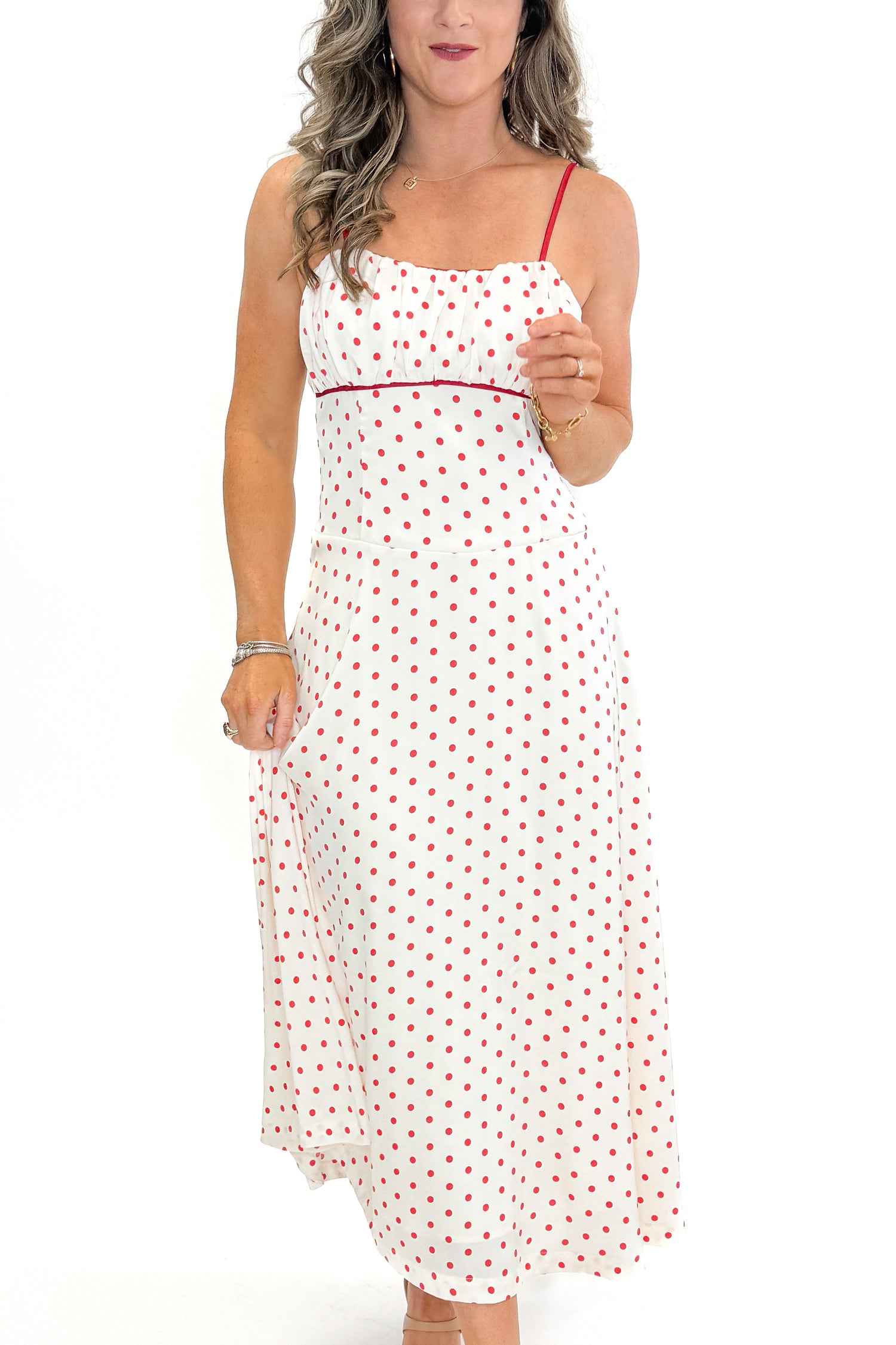 Front detail view of woman wearing Cream &amp; Red Polka Dot Midi Dress by Skies Are Blue against white studio background.