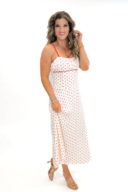 Side view of woman wearing Cream &amp; Red Polka Dot Midi Dress by Skies Are Blue against white studio background.