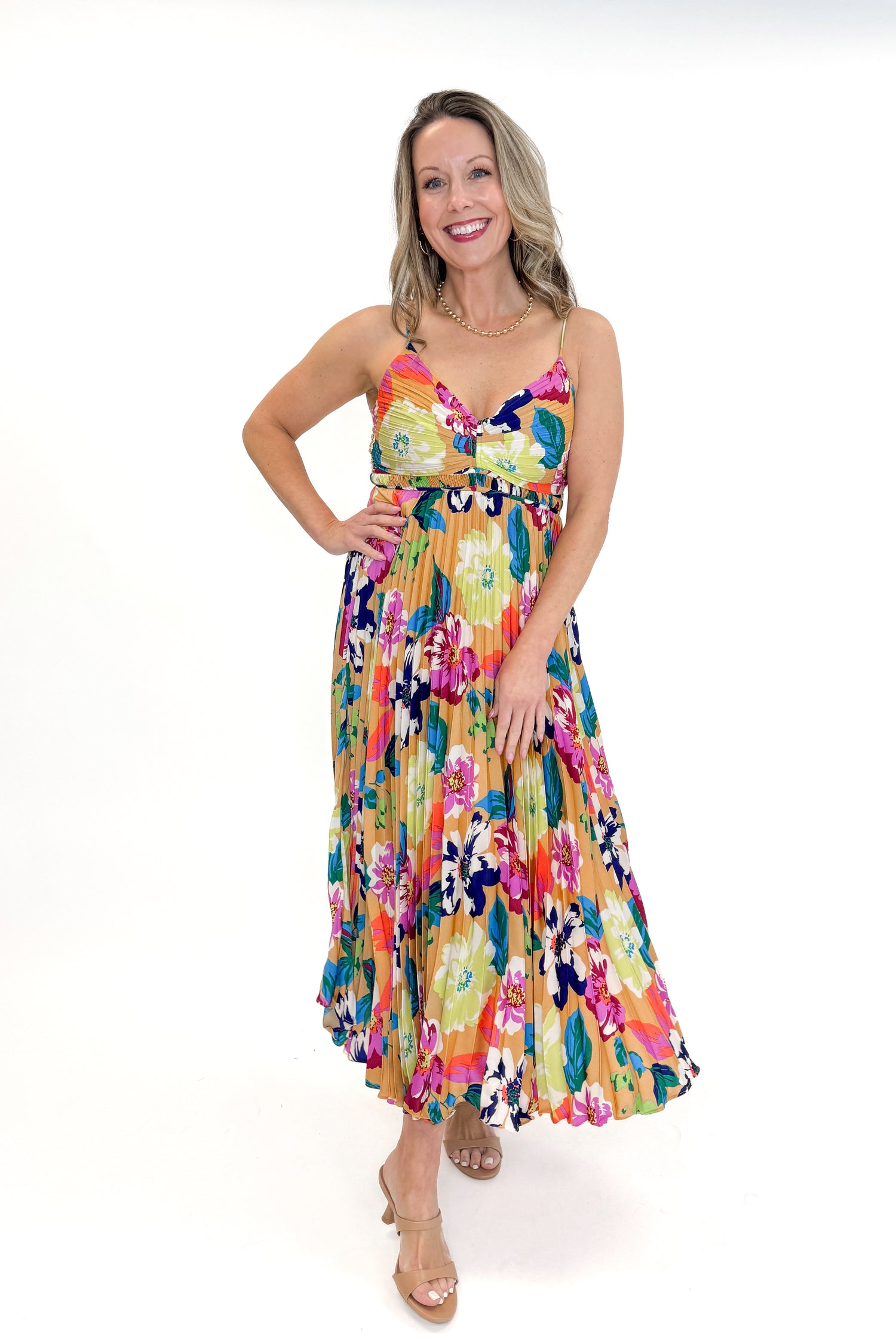 Front view of woman wearing Taupe &amp; Multi Floral Print Pleated Midi Dress by Skies Are Blue against white studio background.