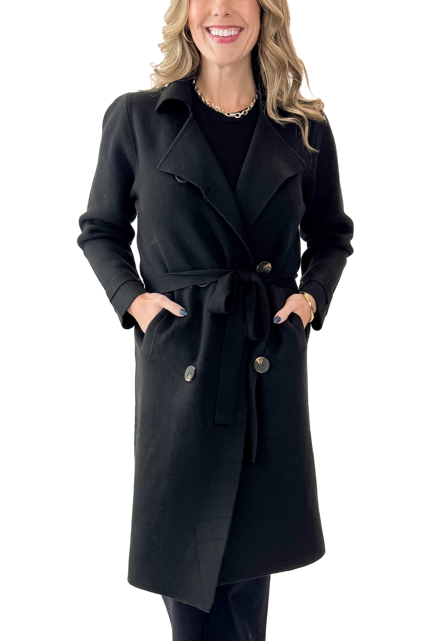 Front view of woman wearing Black Long Peacoat with jeans against white studio background.